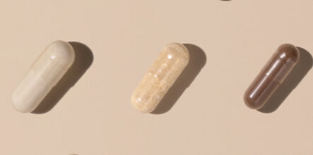 Capsules on light beige top view, hard shadows, creative pattern.