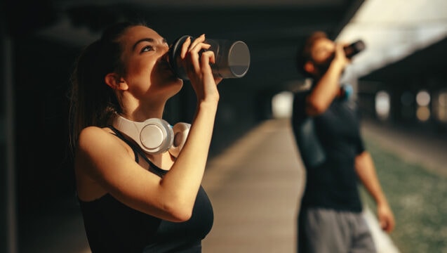 Young woman and man drinking protein shake after workout.