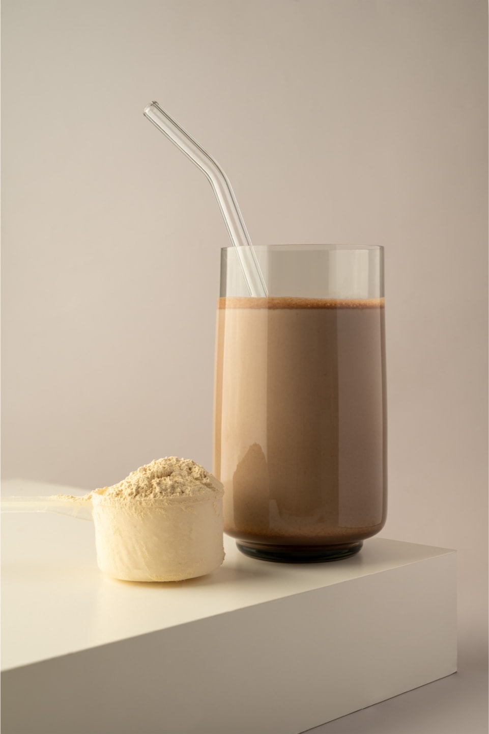 Healthy protein shake drink with straw, and protein powder.